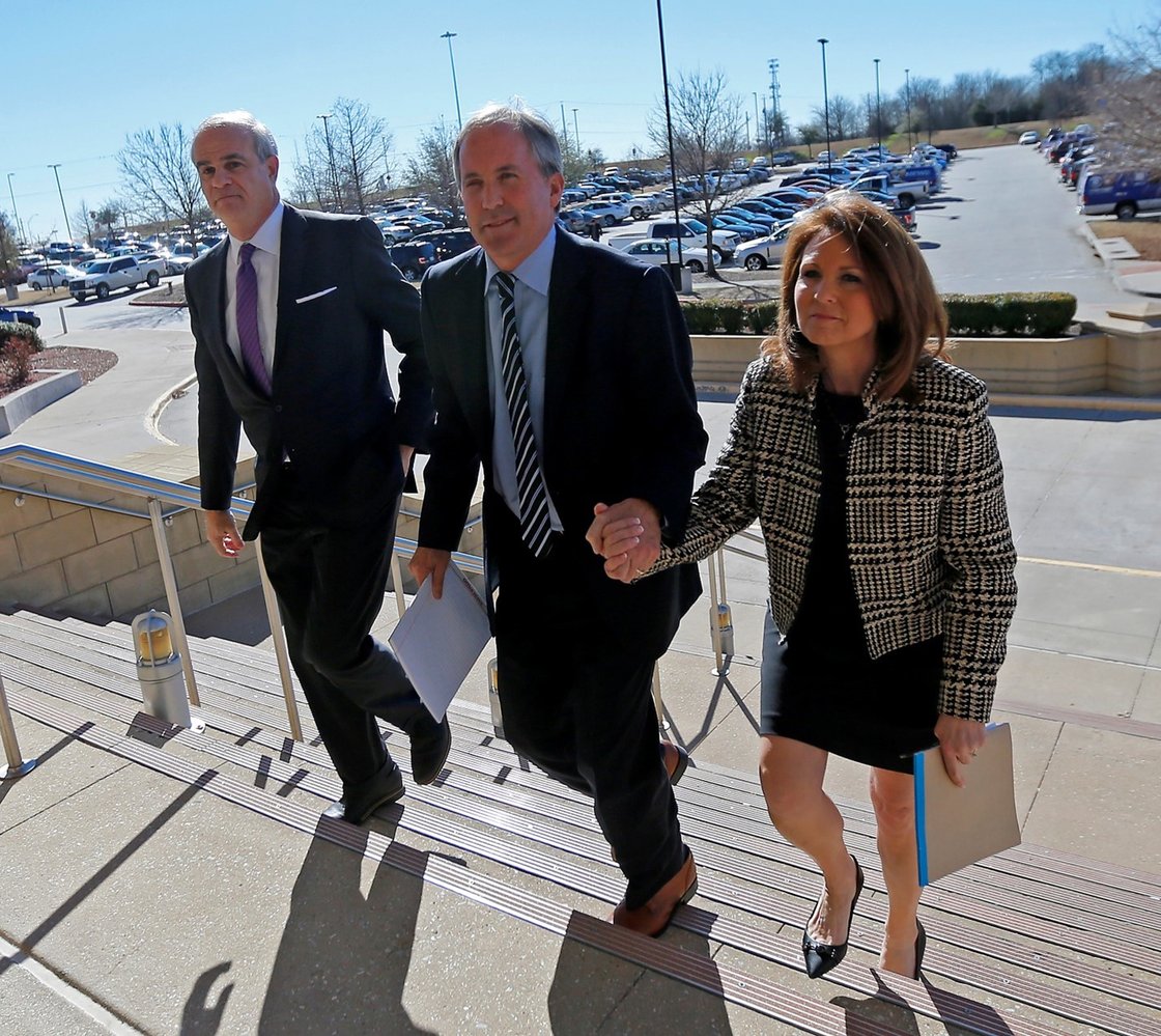 Texas Attorney General Ken Paxton, center, arrives at the Collin County Courthouse in 2017 with his wife Angela and attorney Phillip Hilder 